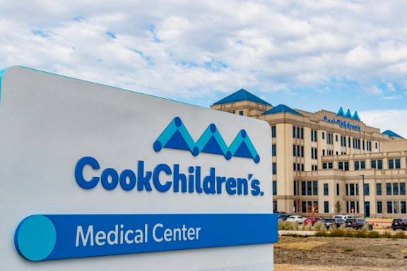 A sign for Cook Children's Medical Center in front of a building.