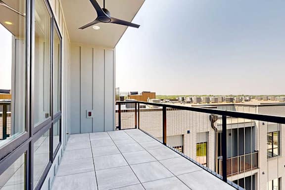 A balcony with a ceiling fan and glass doors.