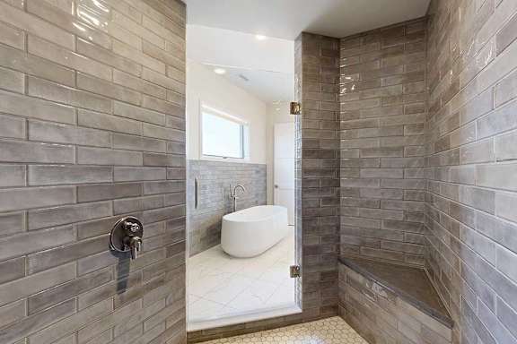 A bathroom with a free standing tub and a tiled walk-in shower.