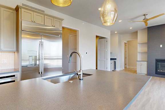 A modern penthouse kitchen with a large island and stainless steel appliances and a large island.