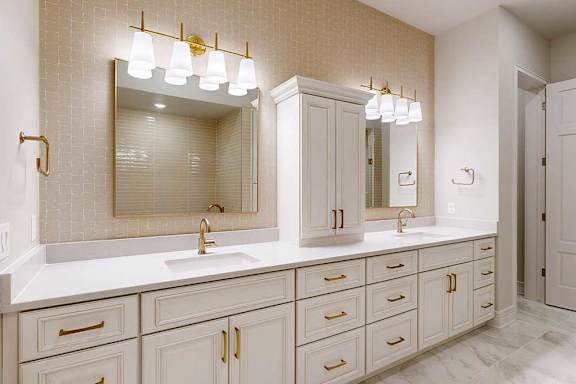 Penthouse primary bathroom with dual vanities and custom built-in cabinetry