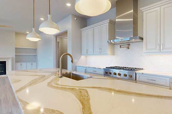 A modern kitchen with a quartz countertop and premium stainless steel appliances.