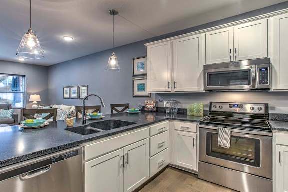 Large open floor plan kitchen with white cabinetry and stainless steel appliances