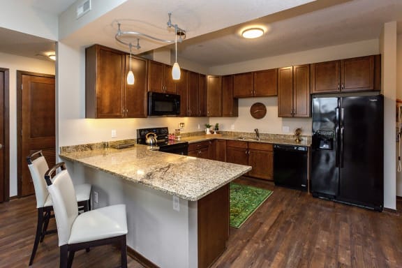 kitchen with fridge, oven, and countertops used for additional seating