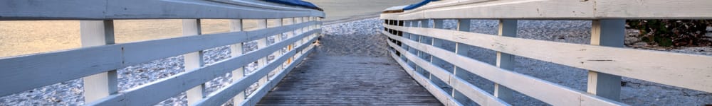 a boardwalk leading to the beach at sunset