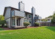 Thumbnail 8 of 8 - A modern house with a grey exterior and a well-maintained lawn.