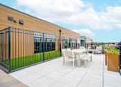 Thumbnail 9 of 13 - A patio with a table and chairs is surrounded by a black fence.