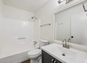 Thumbnail 14 of 15 - A white bathroom with a toilet, sink, and shower.