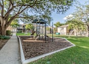 Thumbnail 24 of 27 - Community playground with climbing structure and slides at The Colony Apartments, Universal City, 78148