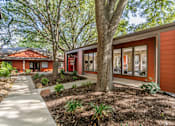 Thumbnail 21 of 27 - Exterior building with large windows and mature trees at The Colony Apartments, Texas