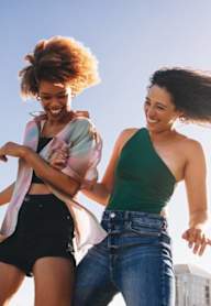 Two people dancing outdoors on a sunny day.