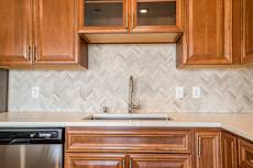 Ascend at Woodbury luxury apartment with herringbone backsplash in kitchen