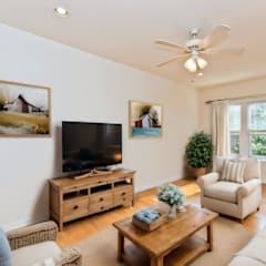 a living room with a ceiling fan and a tv