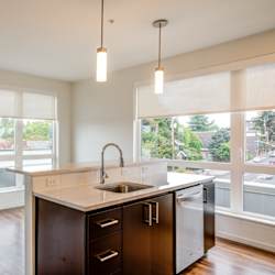 A kitchen with a sink and a refrigerator.