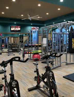 a spacious fitness room with cardio equipment and weights