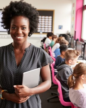 a teacher in a classroom with students working on computers