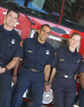 a group of firefighters posing in front of a fire truck