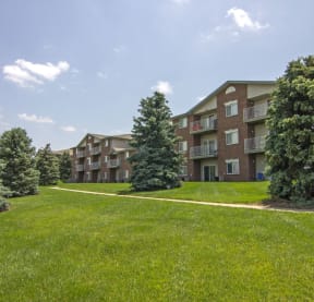 an apartment building with green grass and trees