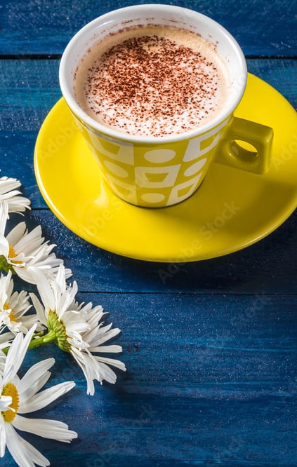 a cup of coffee and a bouquet of daisies on a blue wooden table at Oak Chase I, Tampa, FL