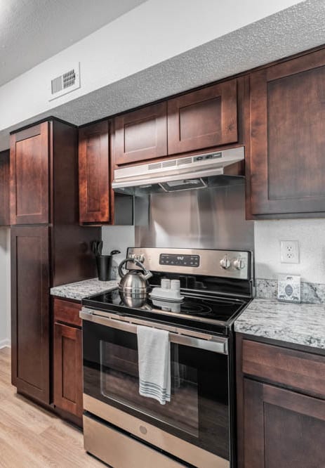 a kitchen with wooden cabinets and stainless steel appliances