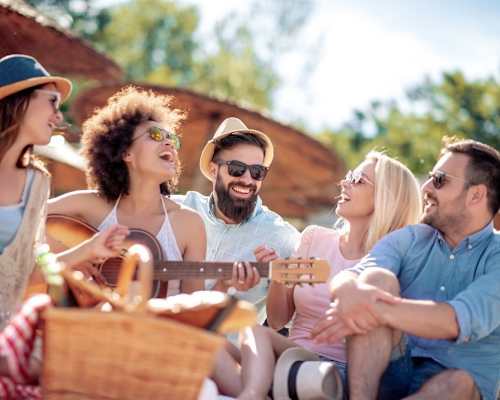 A group of friends enjoying a picnic and playing music together.