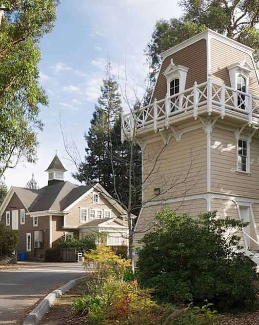 a house with a tower on the side of a street