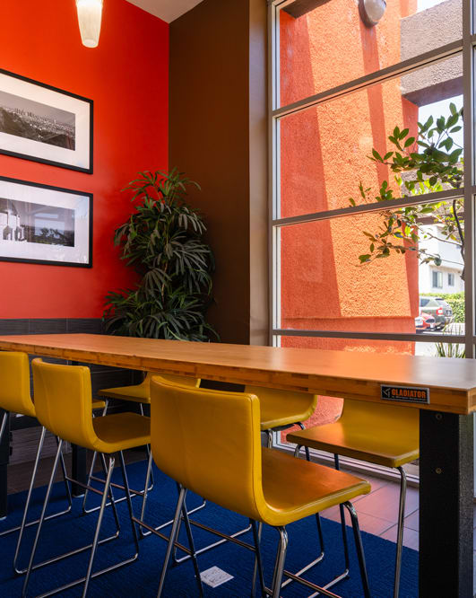 a dining room with yellow chairs and a wooden table