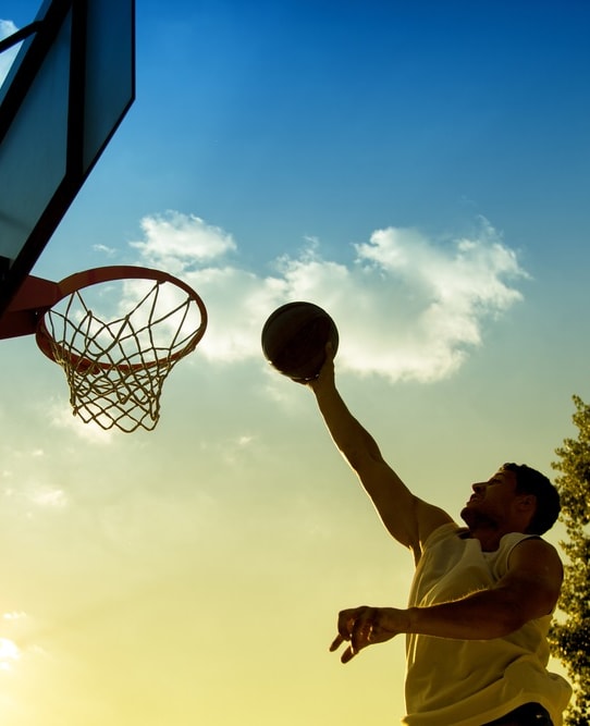 Man Playing Basketball During Sunset