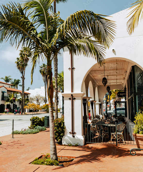 A white building with a balcony and a table outside.
