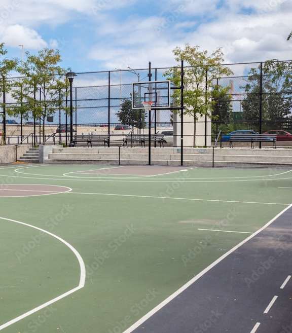 A basketball court with a blue and red surface and a basketball hoop.