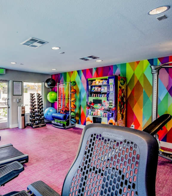 Fusion Las Vegas gym with row of treadmills and bikes and weights.