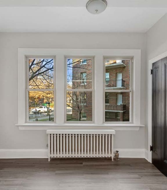 an empty room with four windows and a radiator