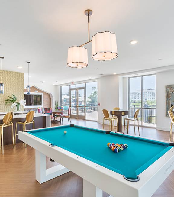 A pool table with a green cloth and a set of billiard balls on it.