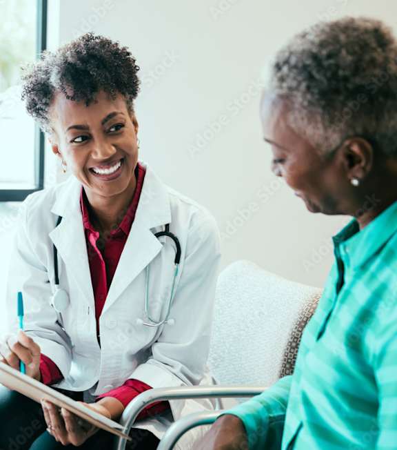 A doctor is consulting with a patient in a bright room.