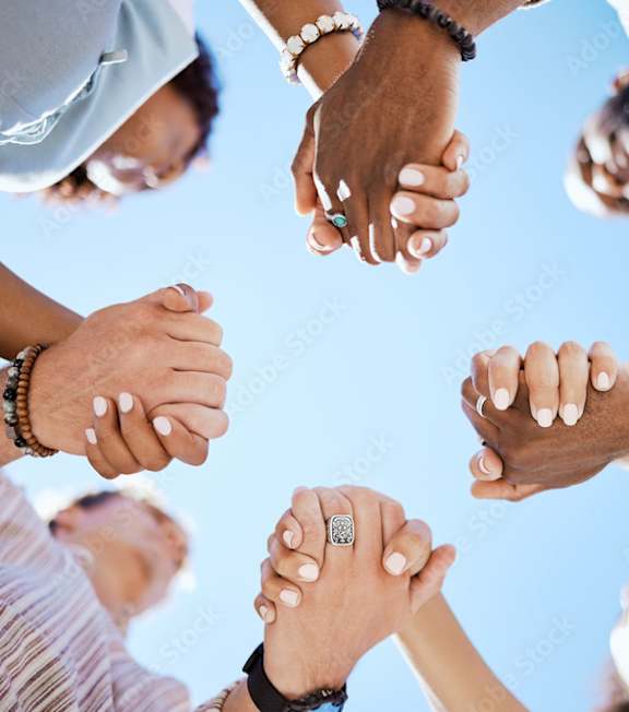A group of people holding hands together in a circle.