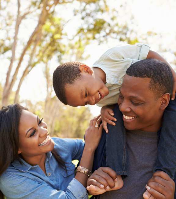 A family of three enjoying a sunny day outdoors.