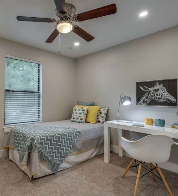 a bedroom with a bed and a ceiling fan