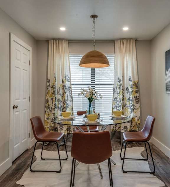 a dining room with a table and chairs in front of a window