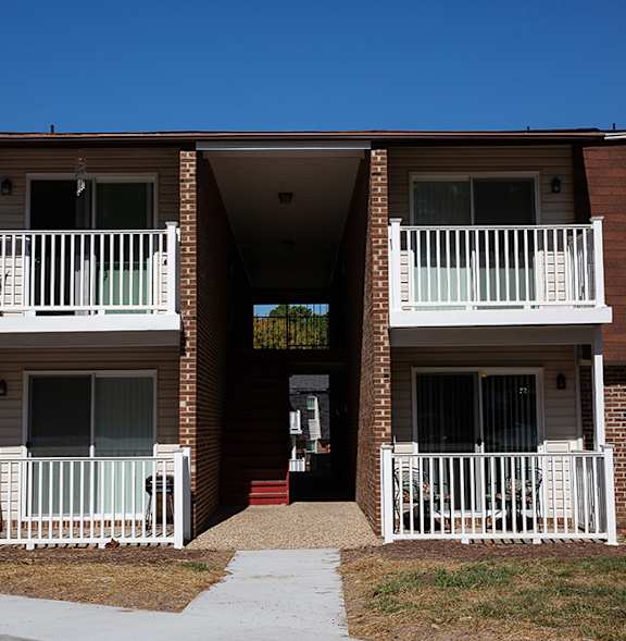 A building with brown brick walls and white railings.