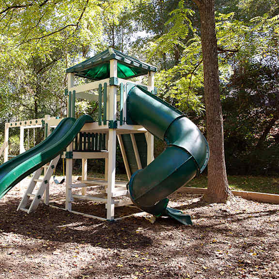 A green and white slide in a playground.