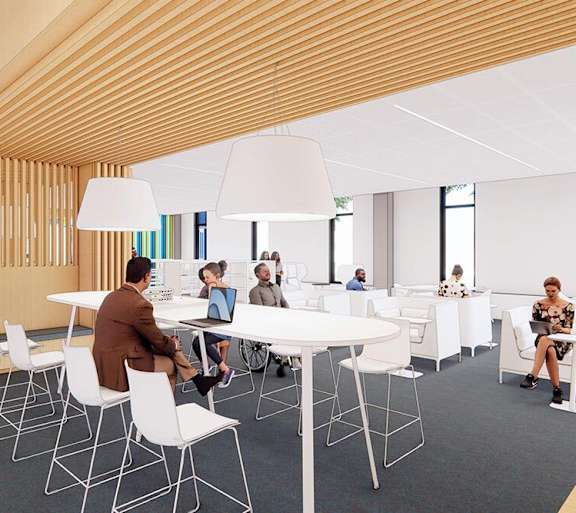 A group of people are sitting around a table in a modern room.
