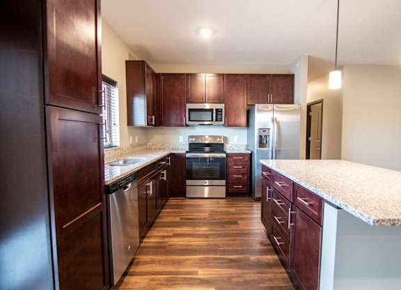 Kitchen with large island and granite counter tops at 360 at Jordan West