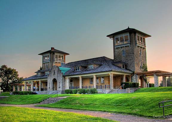 A large house with a tower and a balcony.