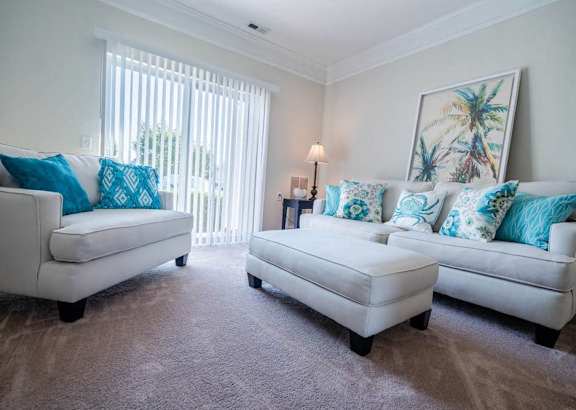 A living room with two white couches and a bench.