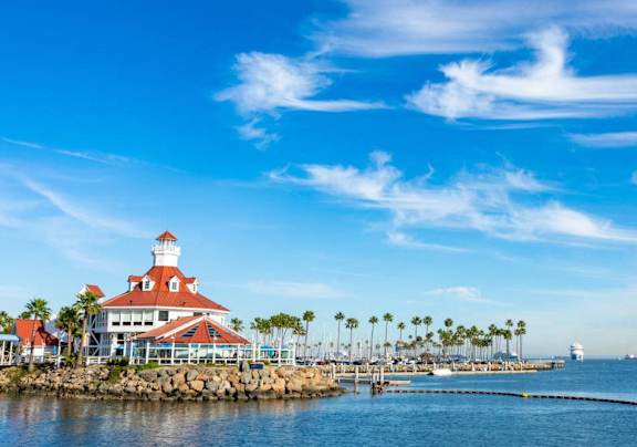 A lighthouse stands on a pier overlooking a calm sea.