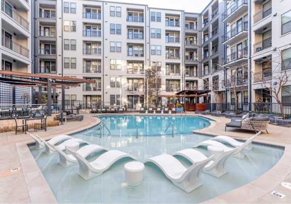 A large swimming pool with a white bench in the middle of it.