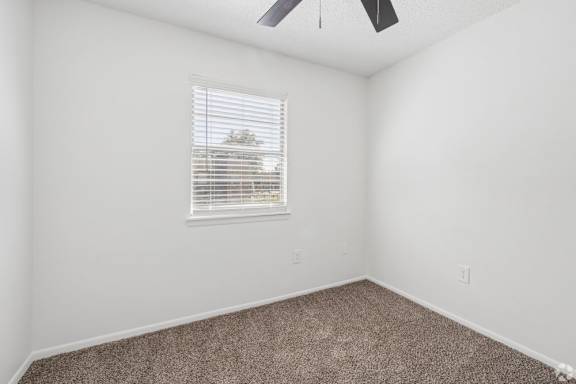 A room with a window and a ceiling fan.