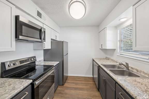 A kitchen with a black stove top oven and a black microwave.
