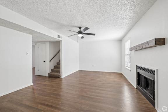 A room with a fireplace and a staircase.