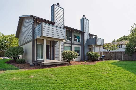 A modern house with a grey exterior and a well-maintained lawn.